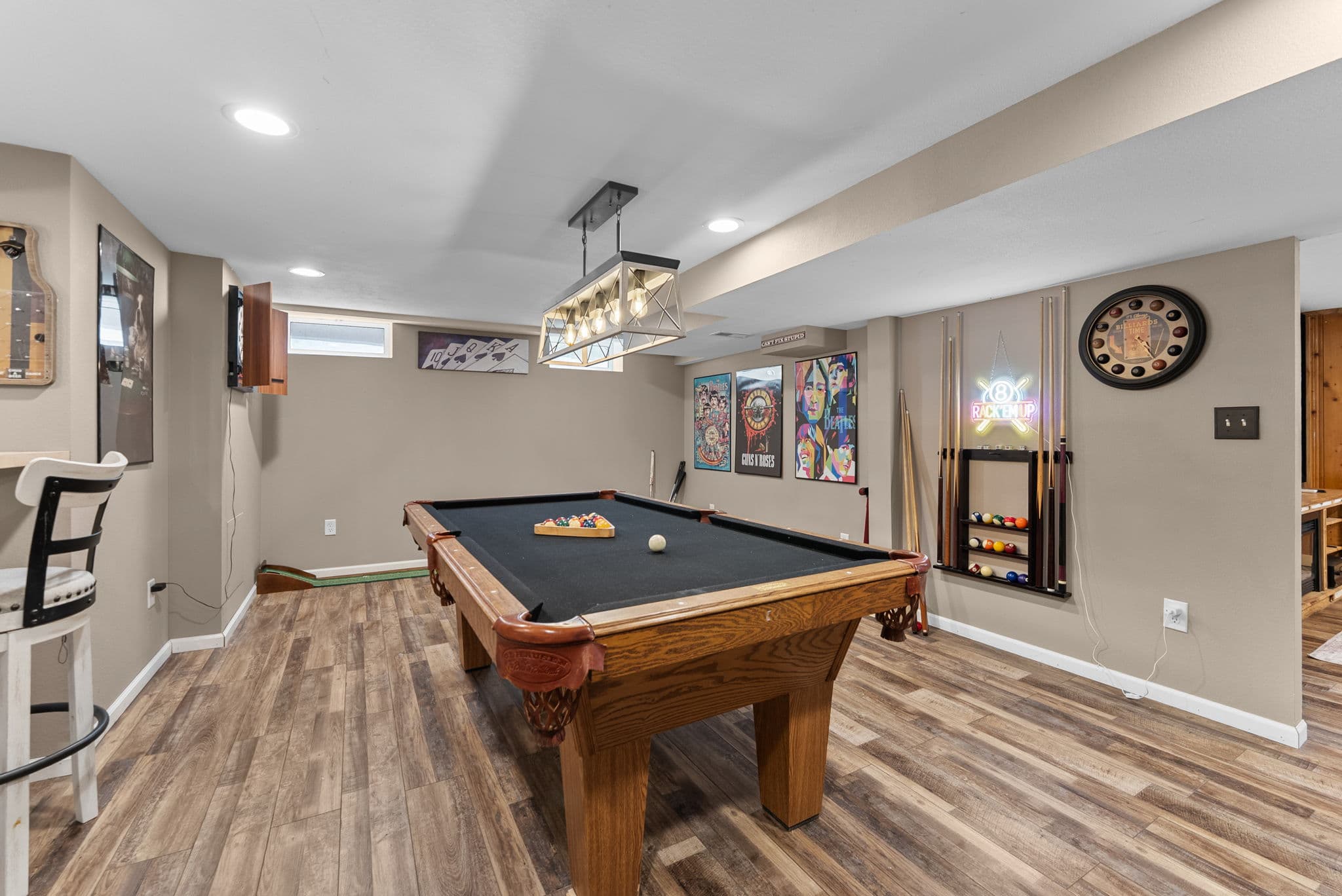 Pool table with a poster wall and neon sign